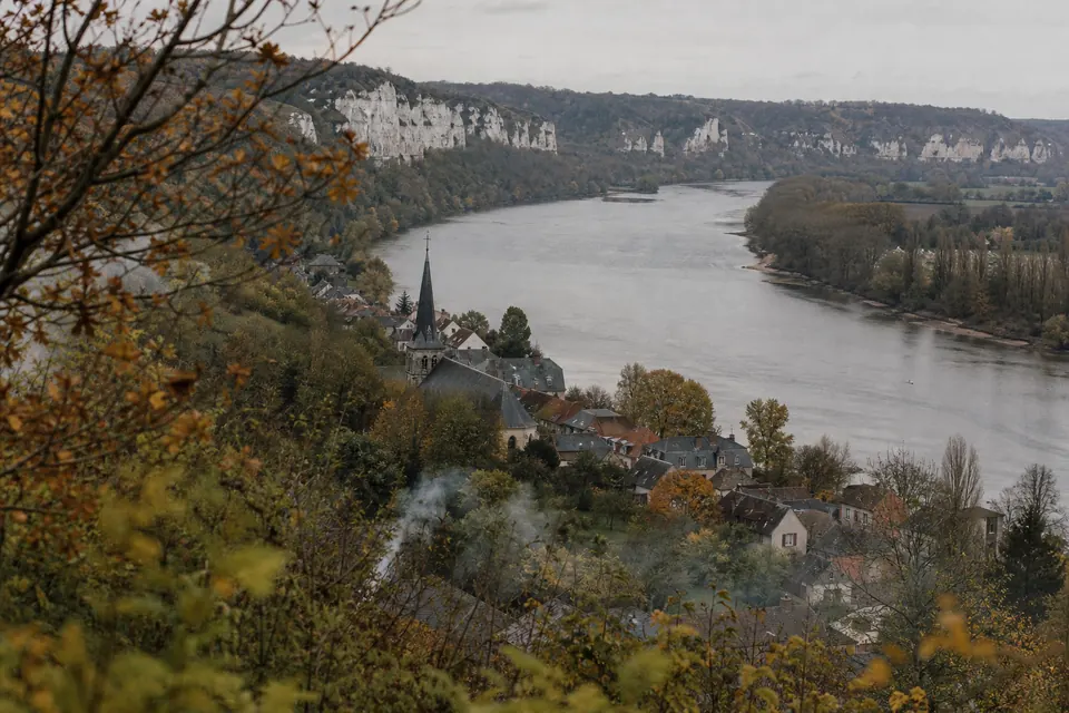 Méandre de la Seine bordé de falaises de craie avec une petite ville en automne